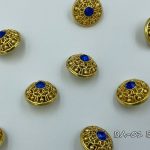 gold button with blue crystal