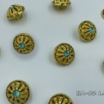 gold button with light blue crystal