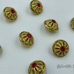 gold button with red crystal