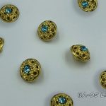 gold button with light blue crystal