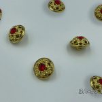 gold button with red crystal