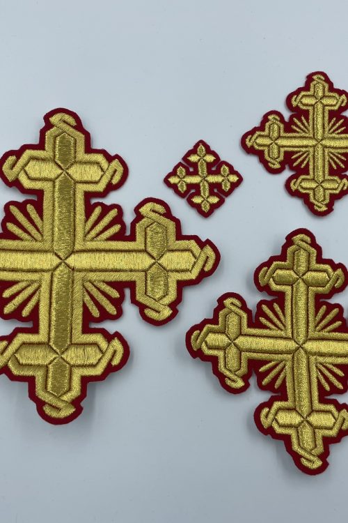 The photo shows a set of embroidered crosses consisting of four gold crosses of various sizes on a red base.