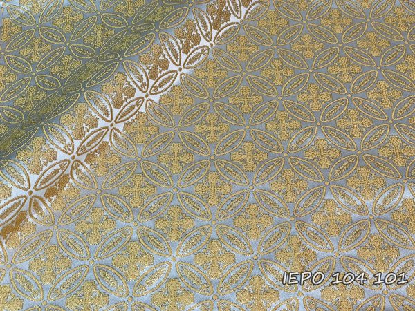 Fabric with a white base, with a design of small gold crosses and branches in repetition.